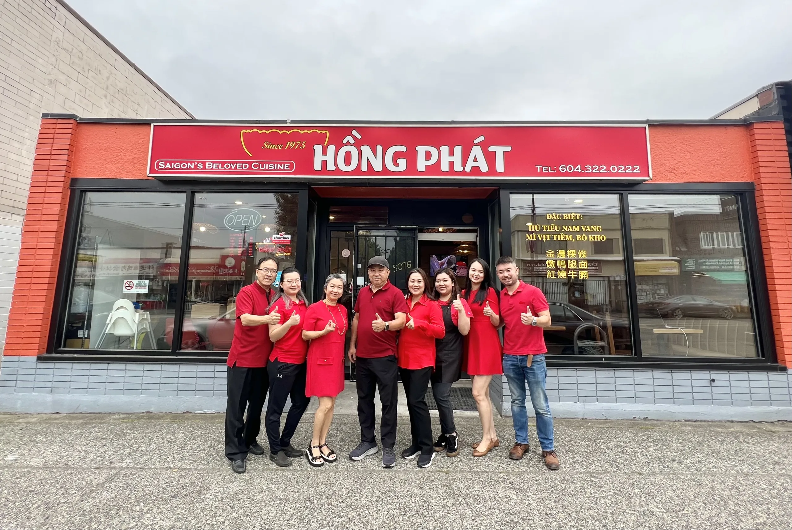 The Hồng Phát team in red shirts giving a thumbs up outside the Victoria Drive storefront